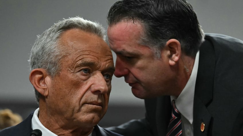 US Secretary of Health and Human Services nominee Robert F. Kennedy Jr. (L) confers with an aide during a Senate Finance Committee hearing on his nomination to be Health and Human Services Secretary, on Capitol Hill in Washington, DC, January 29, 2025. (Photo by ANDREW CABALLERO-REYNOLDS / AFP) (Photo by ANDREW CABALLERO-REYNOLDS/AFP via Getty Images)