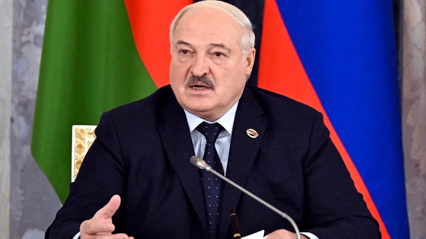 Alexander Lukashenko, Belarus's president with flag behind him