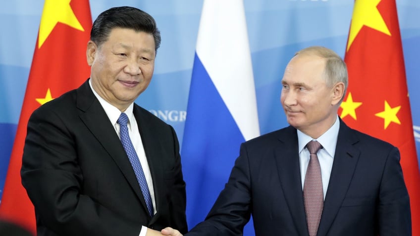 Xi JInping shaking hands with Vladimir Putin