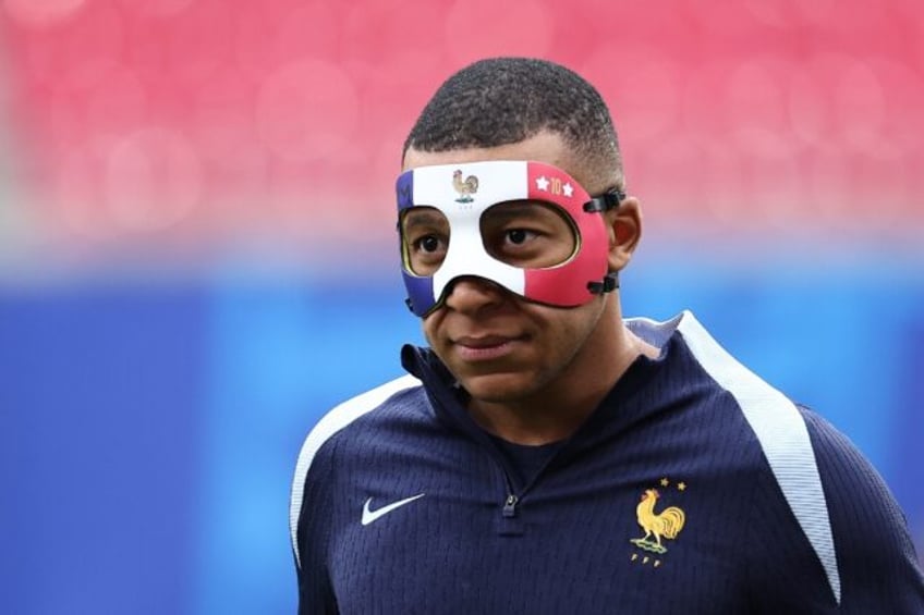 Kylian Mbappe arrives wearing a face mask to take part in a France team training session o