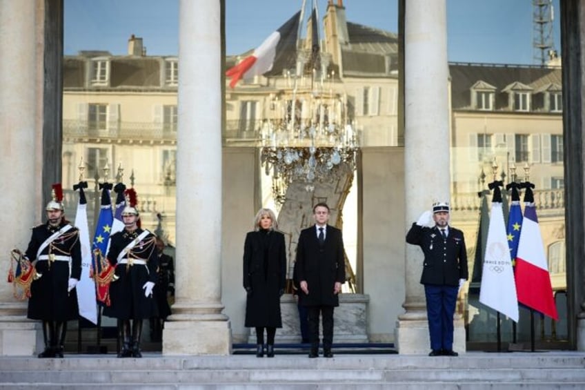 French President Emmanuel Macron and his wife, Brigitte, observe a minute of silence for t