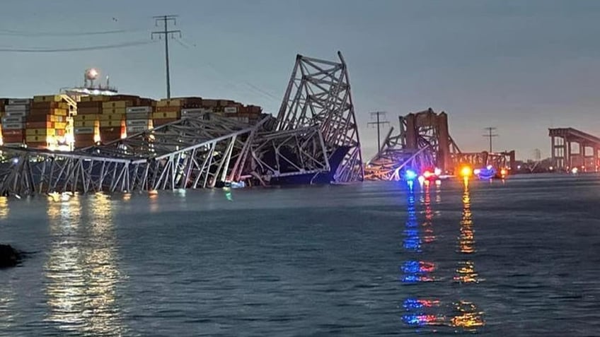 Baltimore bridge collapsed in the background as emergency vehicles are seen in the foreground