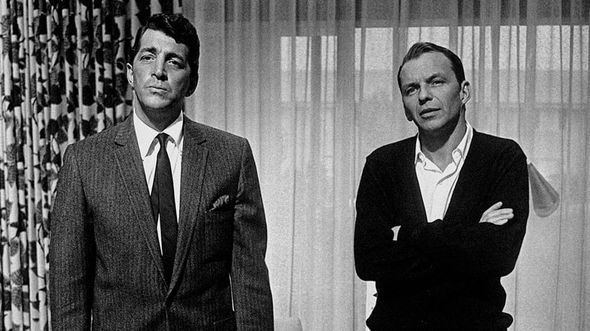 Frank Sinatra and Dean Martin looking concerned as they stand next to each other.