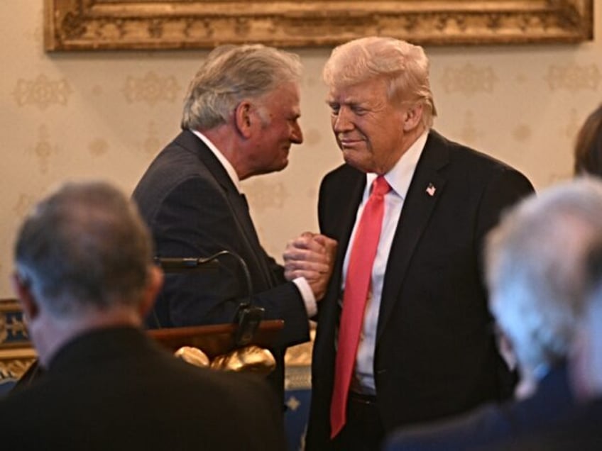 Rev. Franklin Graham shakes hands with US President Donald Trump after addressing an Easte