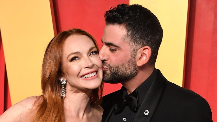 Bader Shammas giving Lindsay Lohan a kiss on the cheek