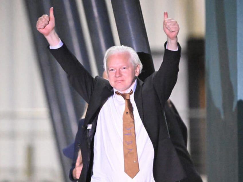 TOPSHOT - WikiLeaks founder Julian Assange gives thumbs up after arriving at Canberra Airp