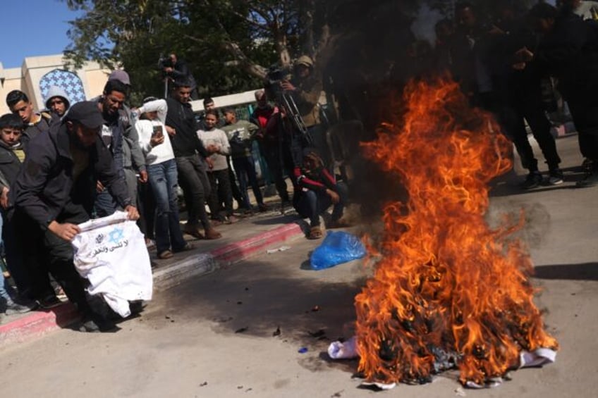 A Palestinian burns a sweatshirt handed to him in Israeli jail, featuring the slogan: "We