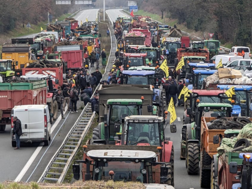 AGEN, FRANCE - JANUARY 22: Farmers with nearly 200 tractors block the A62 freeway to hold a protest against rising taxes, levies, unfair competition and the many difficulties facing the agricultural sector and in Agen, France on January 22, 2024. Farmers were camping out on the freeway this evening in …