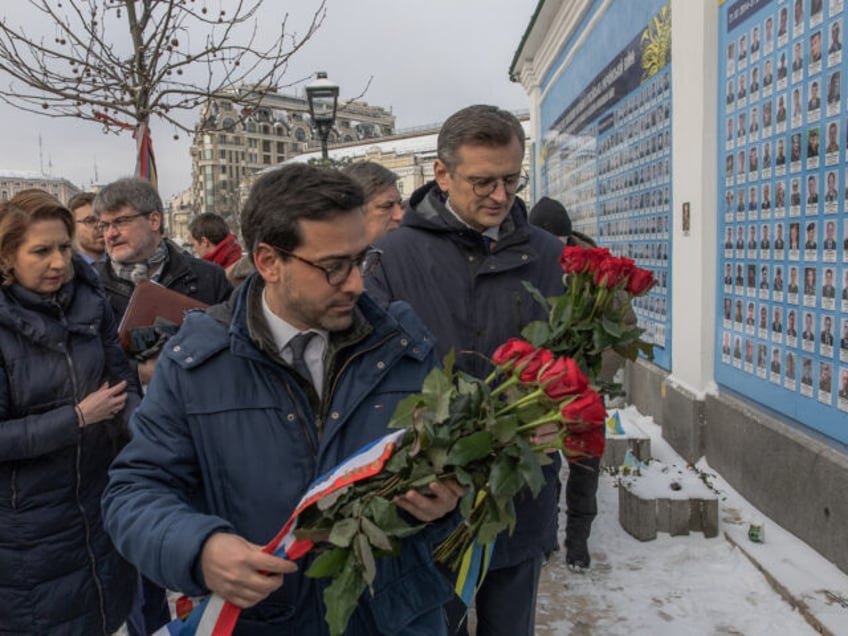 French newly appointed Foreign and European Affairs Minister Stephane Sejourne (C) and Ukrainian Foreign Minister Dmytro Kuleba (R) lay flowers as they visit "The Wall of Remembrance of the Fallen for Ukraine", a memorial for Ukrainian soldiers, in downtown Kyiv, on January 13, 2024, amid the Russian invasion of Ukraine. …