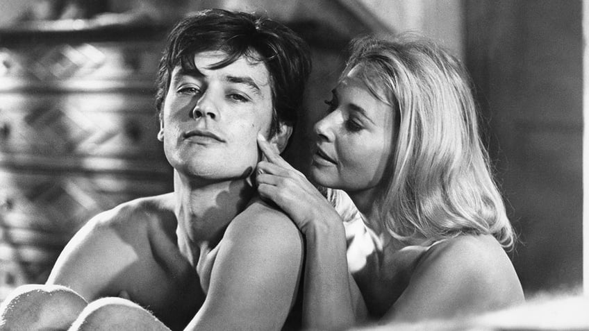 Black and white photo of French actor Alain Delon and American actress Lola Albright