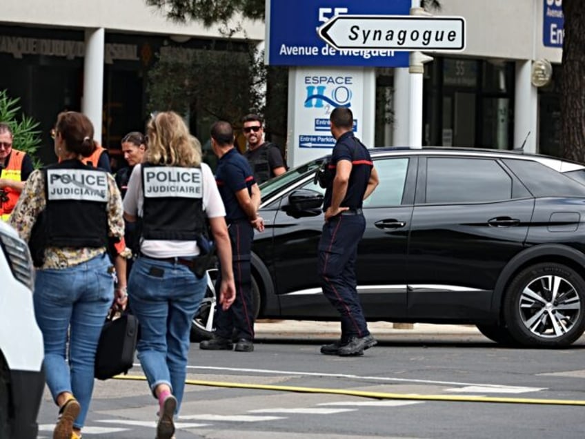 French judicial police officers walk past firefighters following a fire and explosion of c