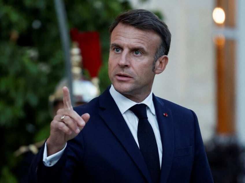 French President Emmanuel Macron waits to welcome Laos' President for a meeting at the Ely