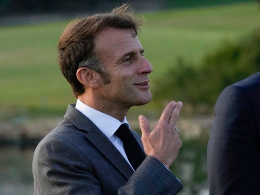 French President Emmanuel Macron gestures as he prepares to pose for a family photo in Pap