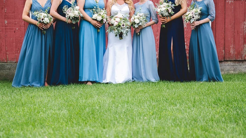 the bride and bridesmaids with occasion clothing and bouquets on the lawn