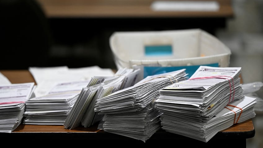 Ballots are stacked on a table at the central count in Baird center