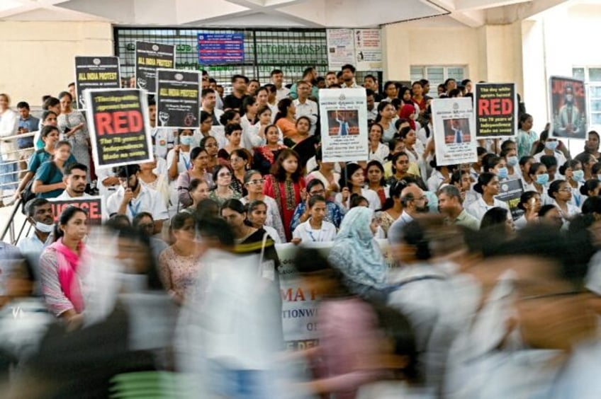 Medical professionals hold posters amid nationwide strike by doctors to condemn the rape a