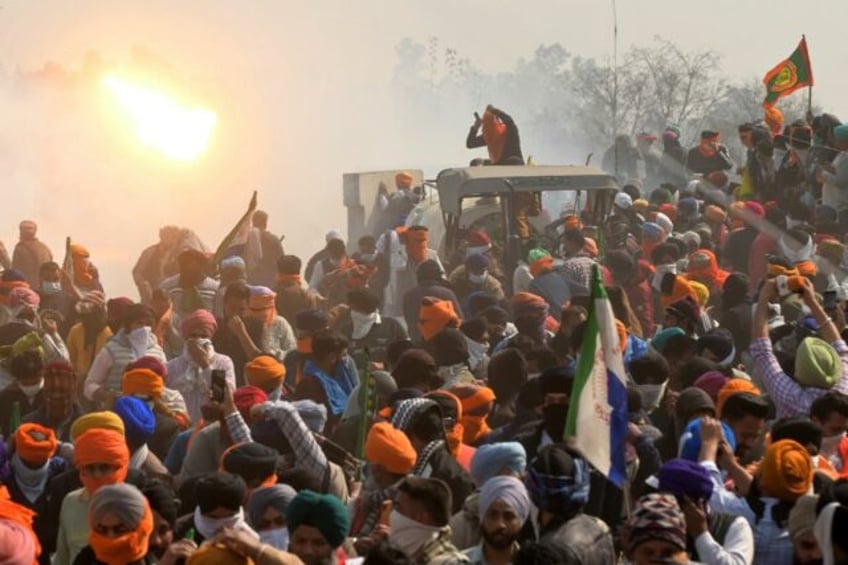 Police fire tear gas to disperse farmers marching towards New Delhi during a protest deman