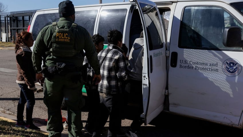 Border Patrol agents with migrants