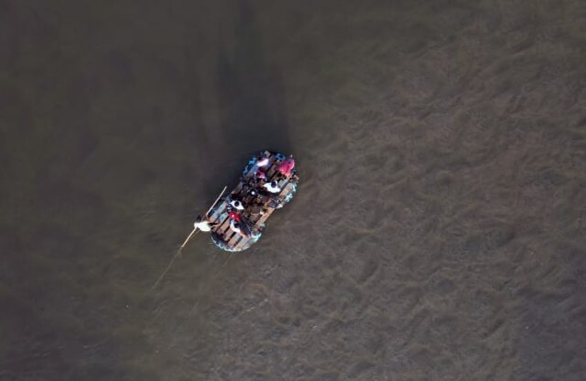 People cross a river between Guatemala and Mexico by raft, a route taken by many undocumen