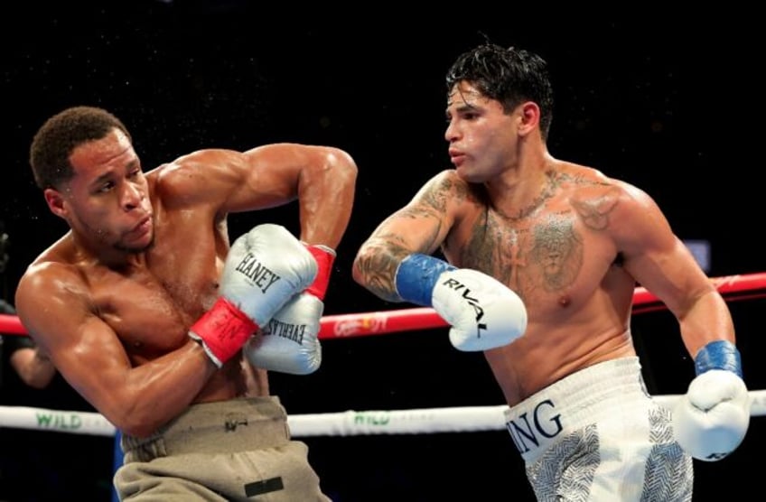 Ryan Garcia (white trunks) punches Devin Haney (gray trunks) on the way to a majority deci