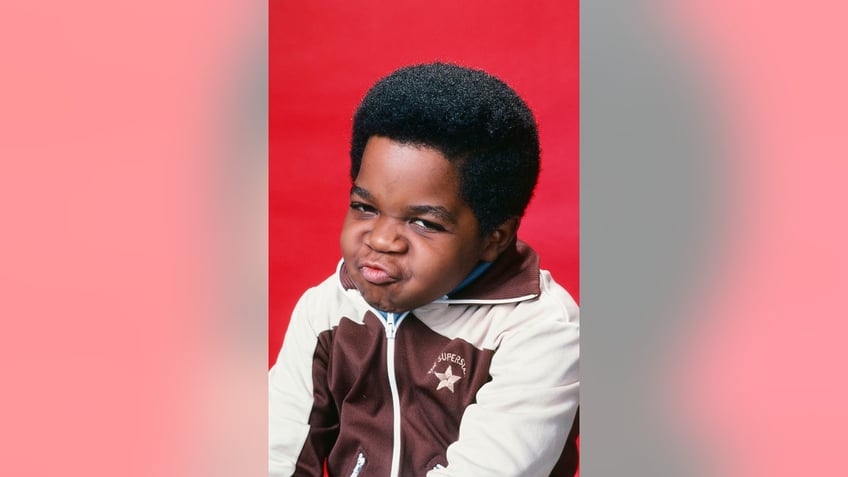 Gary Coleman making a funny face in a white and brown sweater.