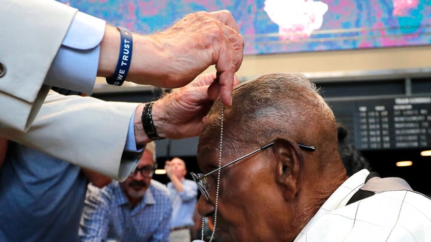 World War II veteran Lawrence Brooks receives a dog tag at the celebration of his 110th birthday at the National World War II Museum in New Orleans.