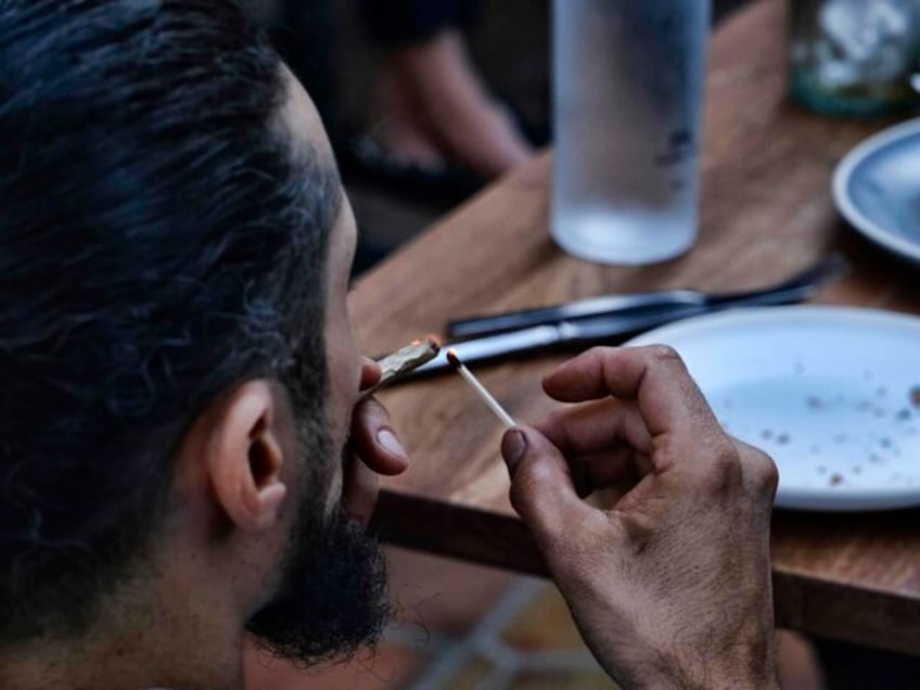 In this Oct. 2, 2019 photo a customer lights up a marijuana cigarette after having lunch a