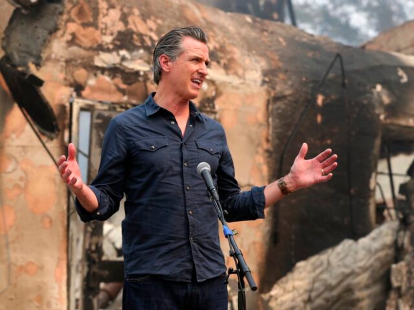 California Governor Gavin Newsom speaks at a press conference while touring areas damaged