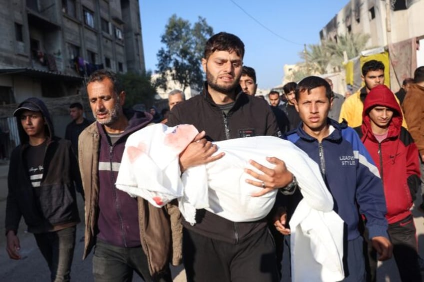 A relative in Khan Yunis, southern Gaza, carries the body of a child -- Civil Defence resc