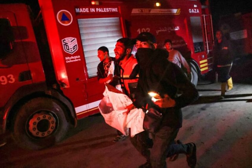 People carry away a victim after an Israeli strike hit a makeshift camp for displaced Pale