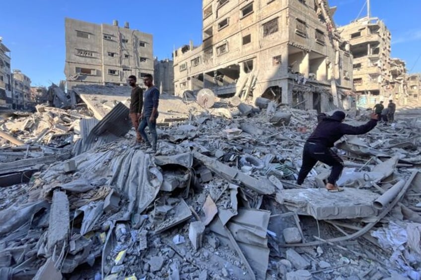 People inspect the rubble of a building hit in an overnight Israeli strike in Beit Lahia i