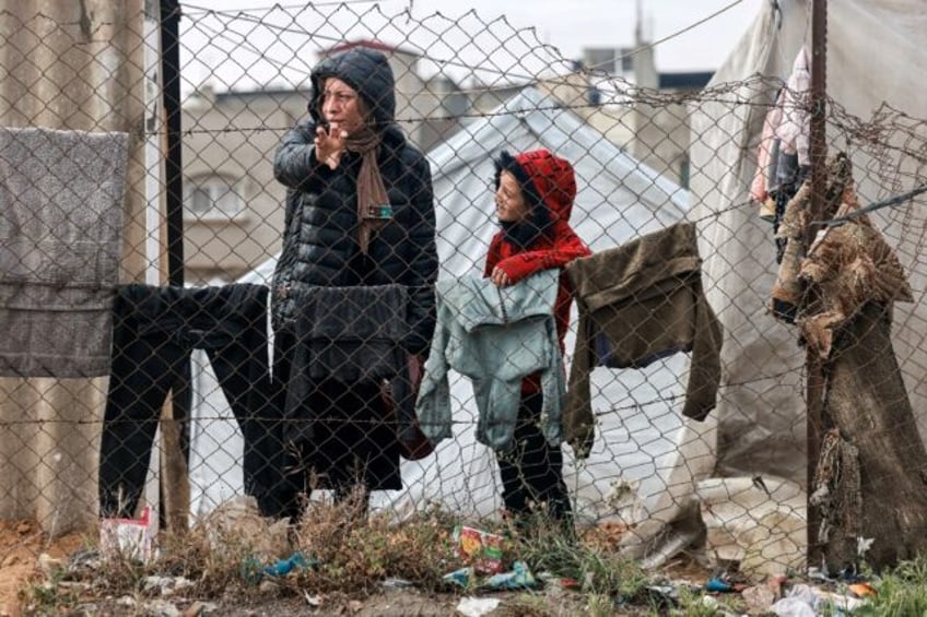 A woman and child stand in Rafah in the southern Gaza Strip