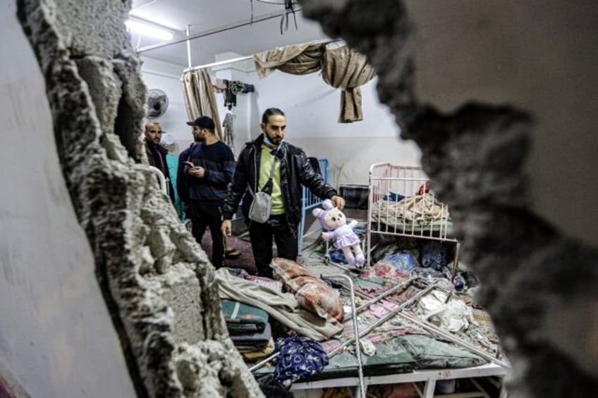 People inspect damage to a room following Israeli bombardment at Nasser hospital in Khan Y