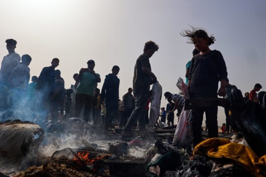 Palestinians gather at the site of an Israeli strike on a camp area housing internally dis