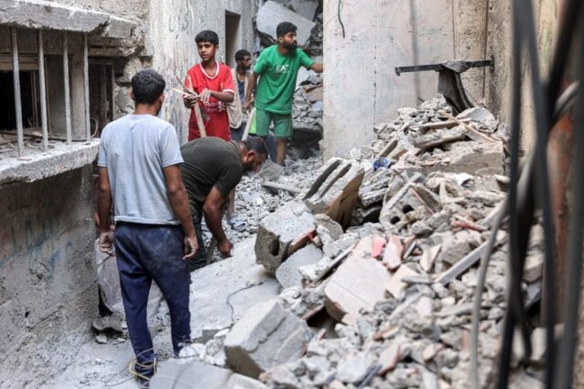 Men search through the rubble after an Israeli strike on the Haniyeh family home in northe