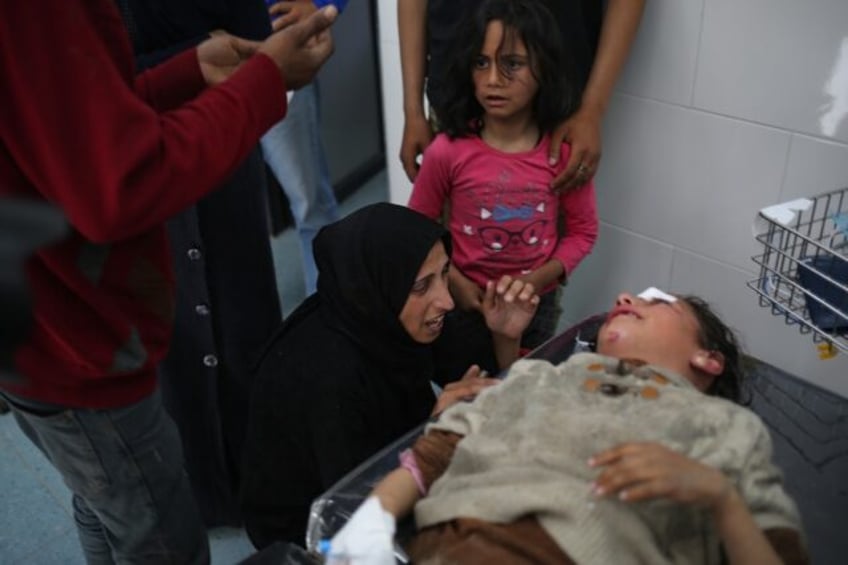 A young Palestinian girl is comforted by her family as she receives treatment after a dead