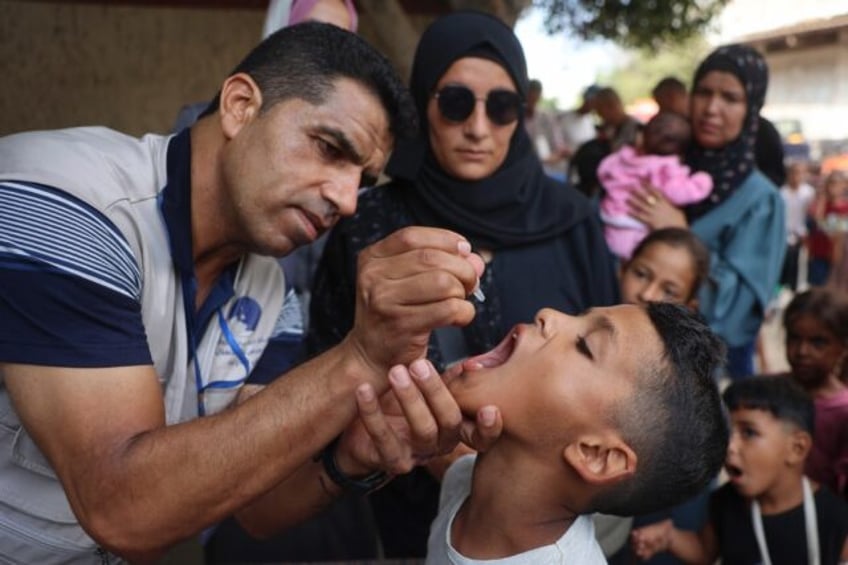 A health worker administers the polio vaccine to a Palestinian child in Zawayda in the cen