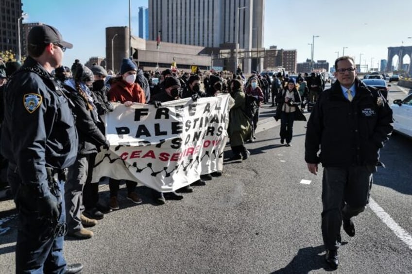 New York City police officers arrest pro-Palestinian protesters as they block the Manhattan side of the Brooklyn bridge