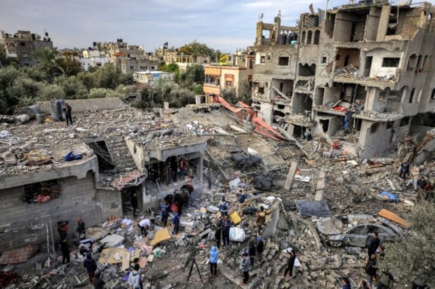 Men recover the body of a victim killed after an Israeli strike at Al-Maghazi refugee camp in central Gaza