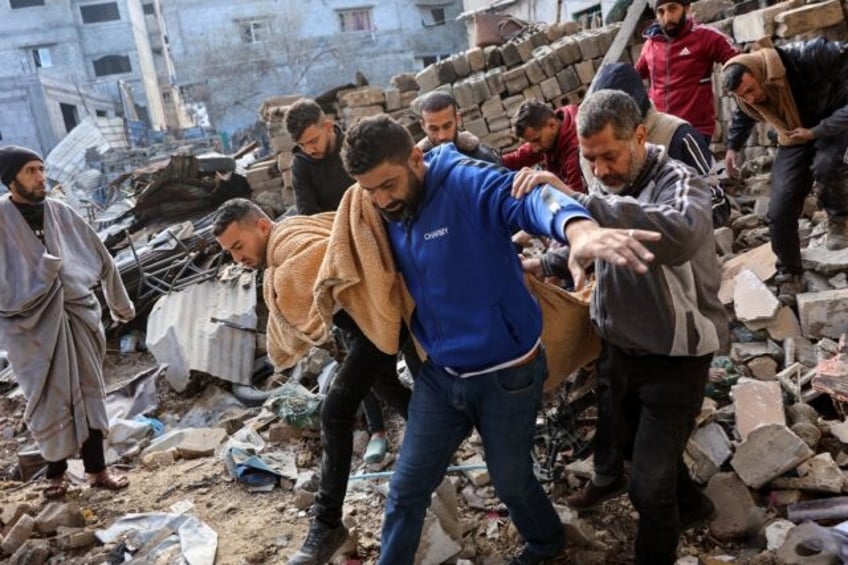 Palestinians carry a body after, according to Civil Defence rescuers, an Israeli strike on