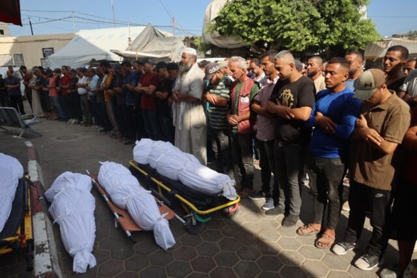 Palestinians mourn over the bodies of victims of Israeli bombardment in Deir el-Balah in c