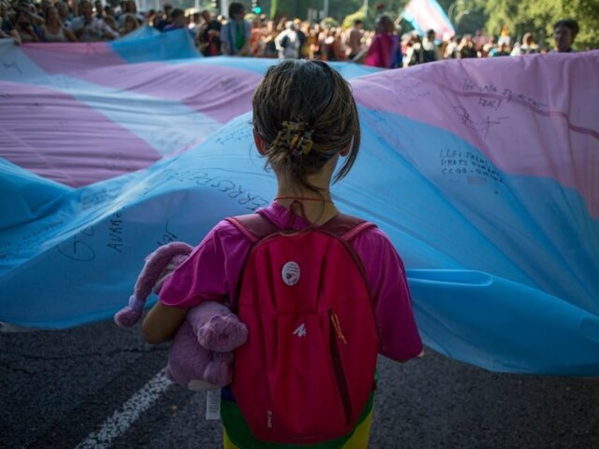 MADRID, SPAIN - 2022/07/09: A girl holds the Transgender Pride flag during the pride march held in one of the most important streets of Madrid. Thousands of people participated in the Madrid pride parade. After two years the march returned to normal with its floats that have characterised it years …