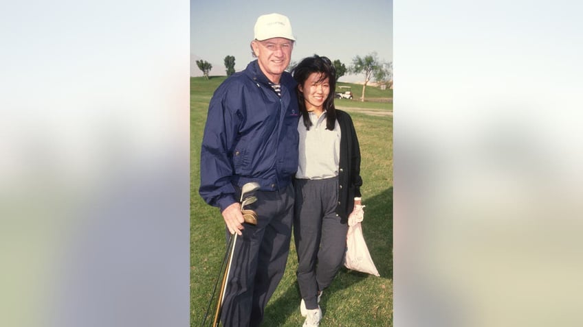 Gene Hackman and Betsy Arakawa Hackman standing on golf course together