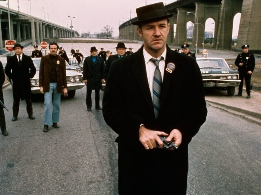 Policeman Gene Hackman is shown in this movie still walking toward the camera. He is holdi