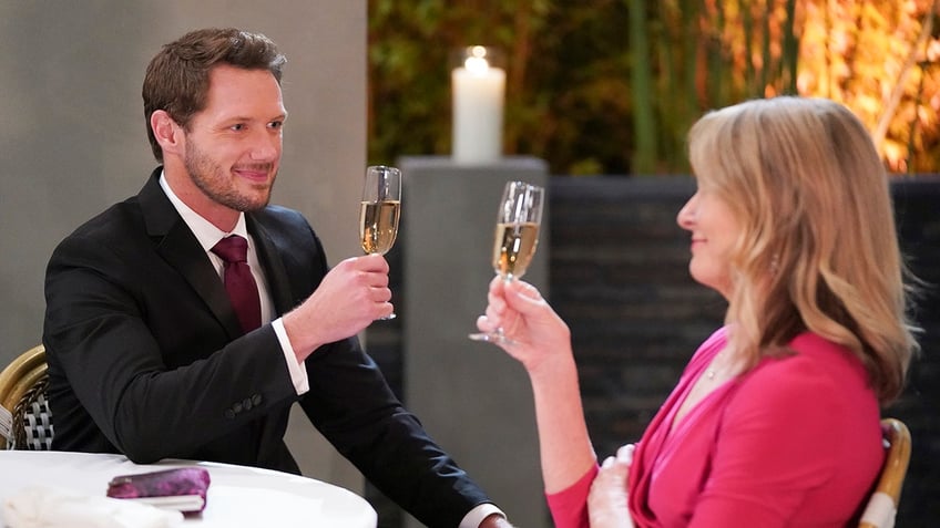 Johnny Wactor holding a champagne glass on the set of general hospital