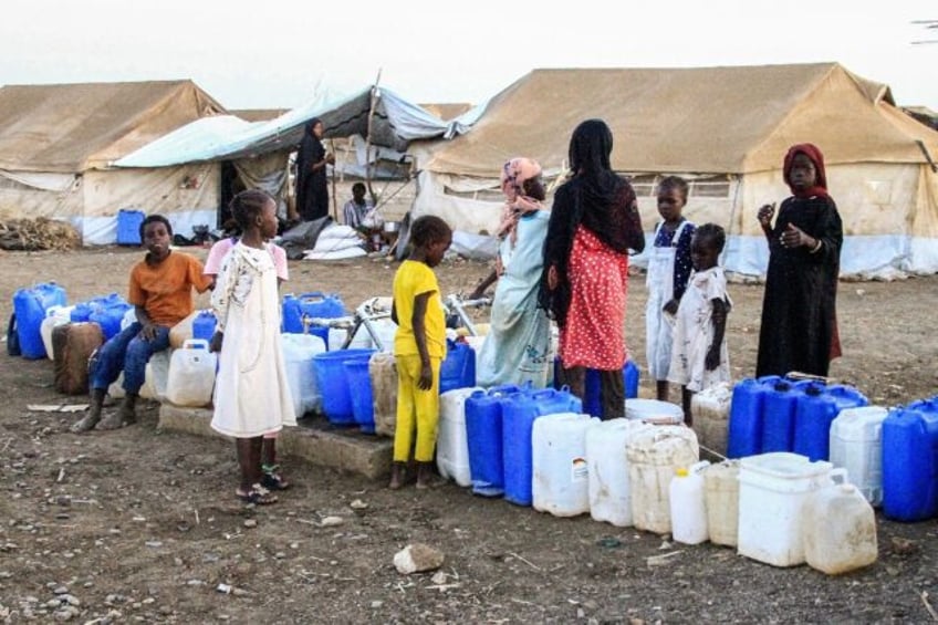 Women and children queue for water at Huri camp for the displaced south of Gedaref in east