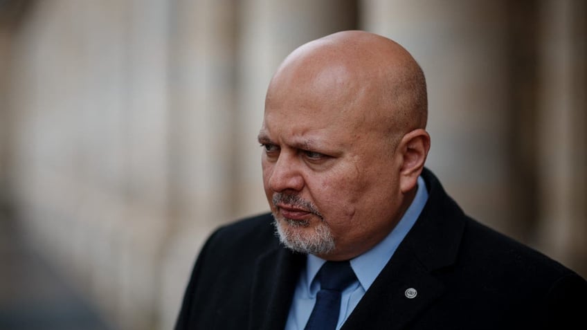 Karim Khan looking serious in a suit and tie