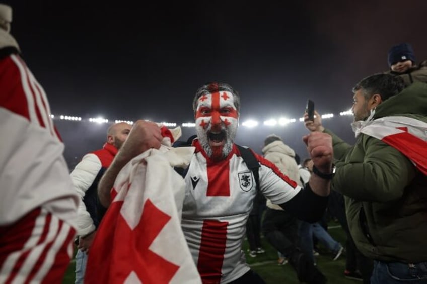 Georgia fans invaded the pitch in celebration after their team beat Greece on penalties to