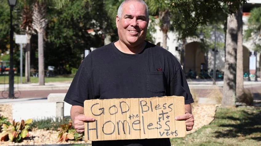 Jeff Gray holds cardboard sign