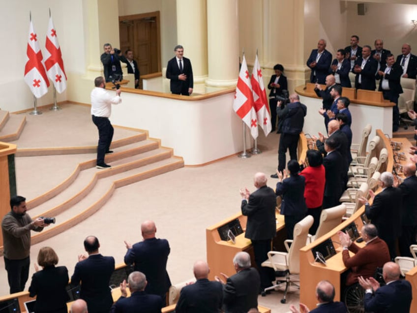 Georgian president-elect Mikheil Kavelashvili is greeted by the electoral college members